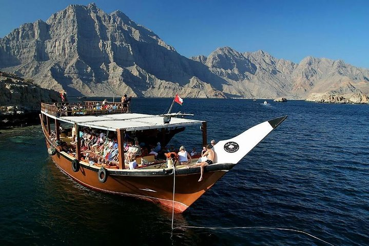 Explore the stunning Khor Shimm aboard a traditional Omani dhow surrounded by majestic mountains and inviting waters while keeping an eye out for playful dolphins along the way.